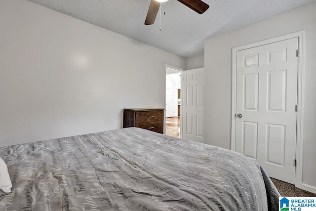 carpeted bedroom with a textured ceiling and ceiling fan