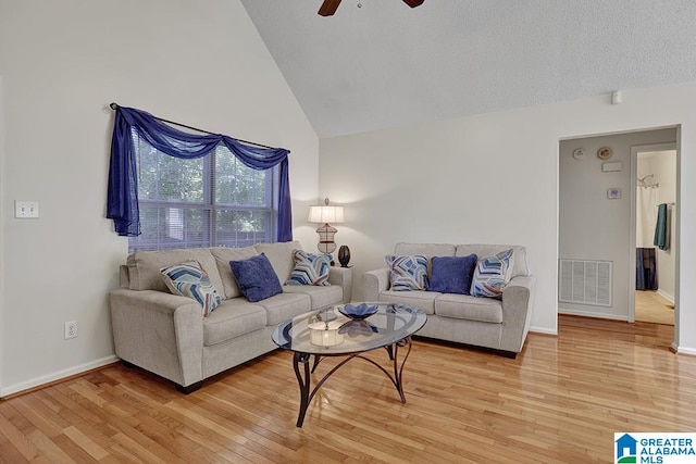 living room with ceiling fan, light wood-type flooring, and high vaulted ceiling