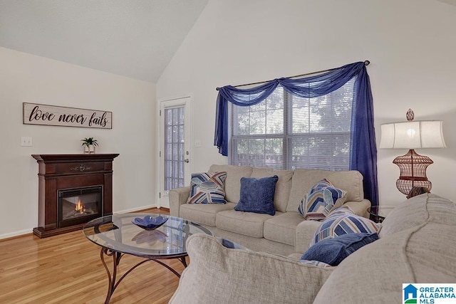 living room with high vaulted ceiling and light hardwood / wood-style floors