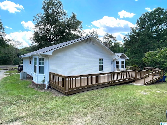 back of house with a lawn, a wooden deck, and central AC