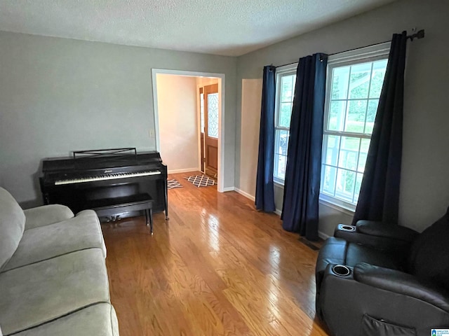 living room featuring a textured ceiling and light hardwood / wood-style floors