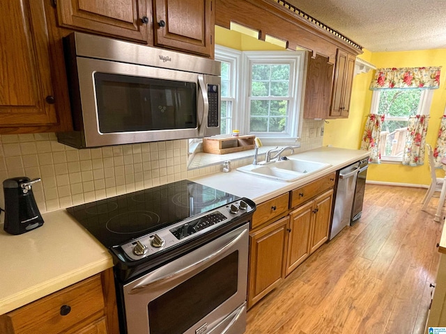 kitchen with decorative backsplash, light hardwood / wood-style floors, and stainless steel appliances