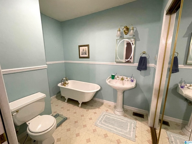 bathroom featuring toilet, tile patterned floors, and a tub