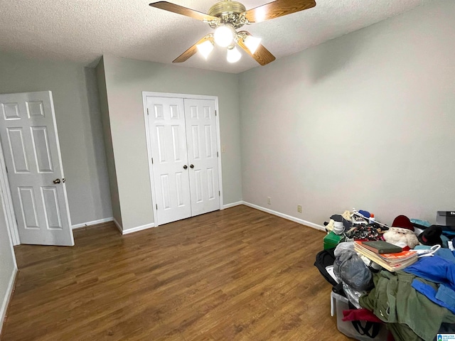 bedroom with hardwood / wood-style floors, ceiling fan, a closet, and a textured ceiling