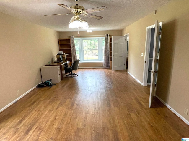 interior space featuring a textured ceiling, ceiling fan, and light wood-type flooring