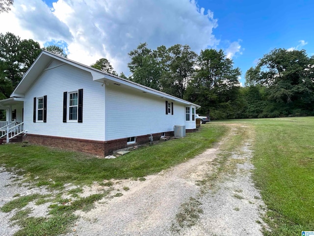 view of side of home with a yard and cooling unit