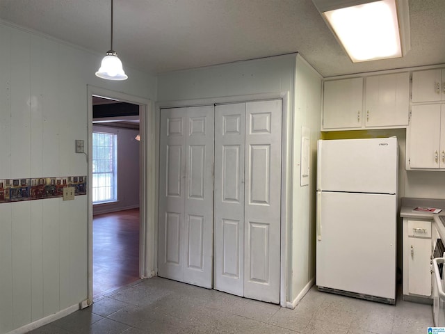 kitchen featuring light tile patterned flooring, hanging light fixtures, white cabinetry, and white refrigerator