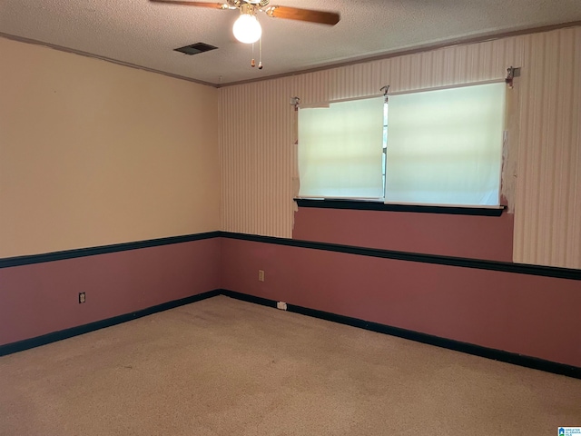 carpeted empty room with ceiling fan and a textured ceiling