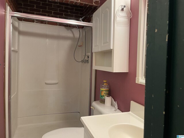 bathroom with sink, an enclosed shower, and toilet