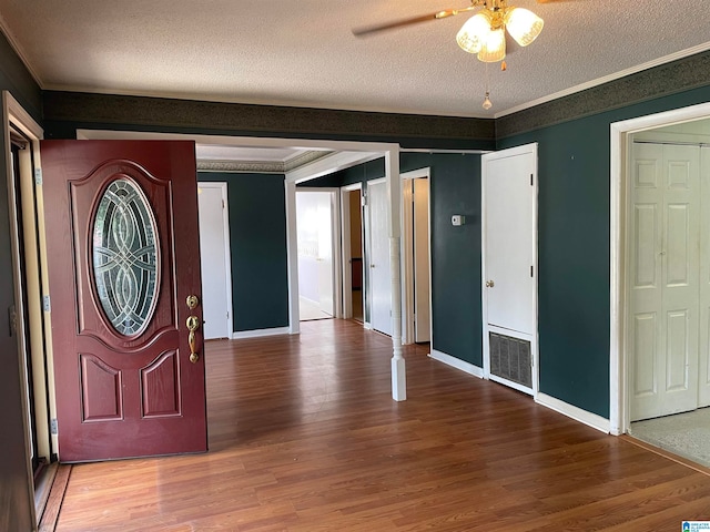 entrance foyer with hardwood / wood-style floors, crown molding, ceiling fan, and a textured ceiling