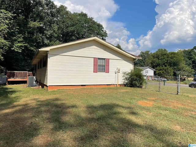 view of home's exterior featuring a lawn, central air condition unit, and a wooden deck