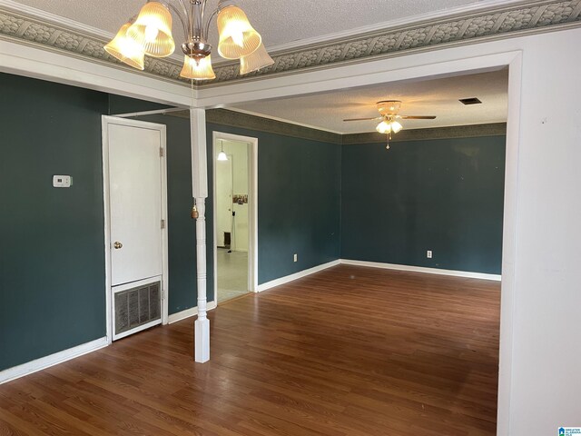 empty room featuring ceiling fan with notable chandelier, wood-type flooring, ornamental molding, and a textured ceiling