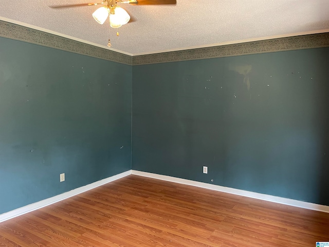 empty room featuring ceiling fan, a textured ceiling, crown molding, and wood-type flooring