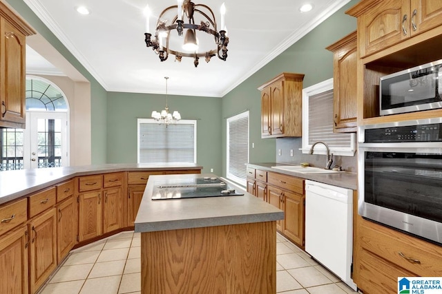 kitchen with appliances with stainless steel finishes, an inviting chandelier, sink, light tile patterned floors, and a center island