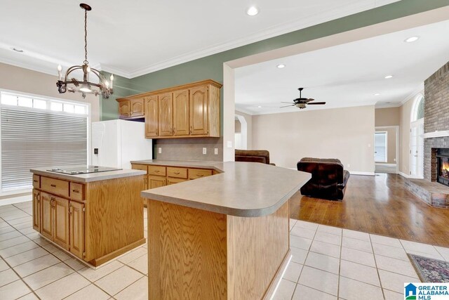 kitchen featuring a kitchen island, ceiling fan with notable chandelier, light hardwood / wood-style floors, a fireplace, and white fridge with ice dispenser