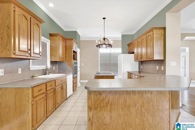 kitchen with light tile patterned flooring, sink, hanging light fixtures, kitchen peninsula, and white appliances