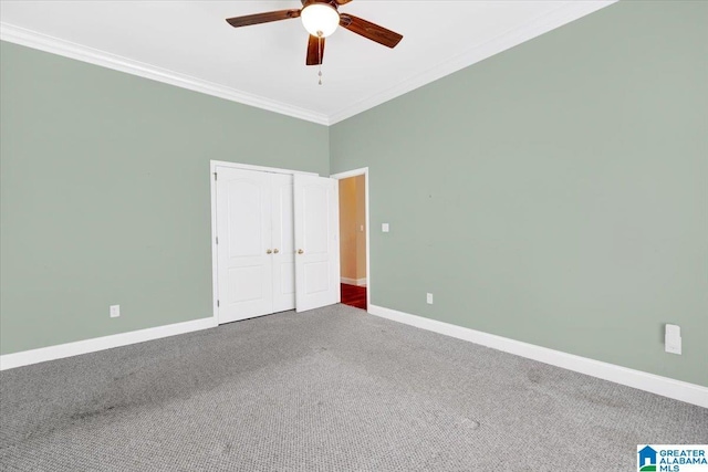 unfurnished bedroom with ornamental molding, carpet floors, ceiling fan, and a closet