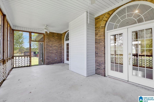 unfurnished sunroom featuring ceiling fan and french doors