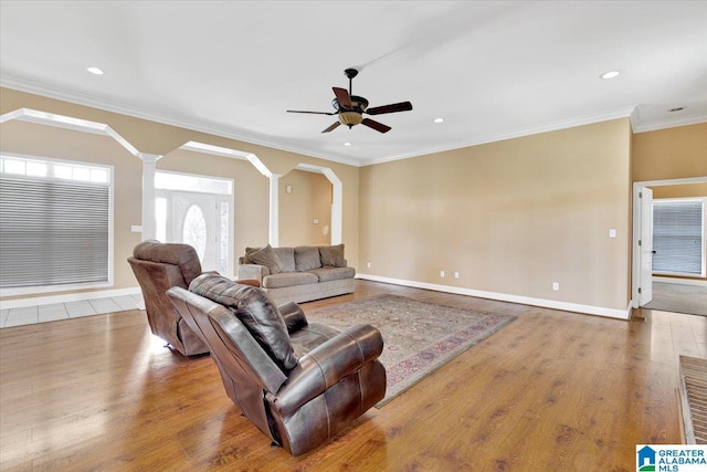 living room featuring decorative columns, ornamental molding, hardwood / wood-style floors, and ceiling fan