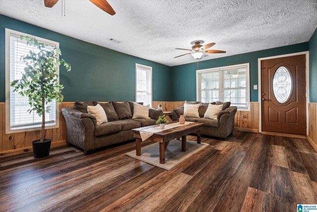 living room featuring ceiling fan, a textured ceiling, and light hardwood / wood-style flooring