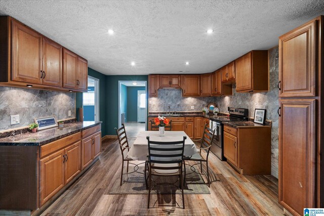 bedroom featuring ceiling fan, a textured ceiling, ensuite bath, and wood-type flooring