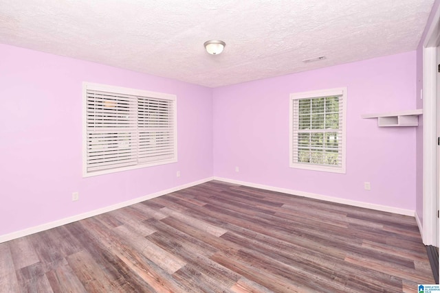 spare room featuring a textured ceiling and hardwood / wood-style floors