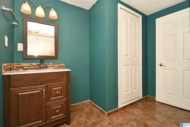 bathroom featuring tile patterned flooring, a textured ceiling, and vanity