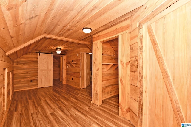 bonus room with wood walls, wooden ceiling, hardwood / wood-style floors, and a barn door