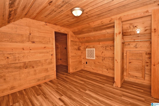 additional living space with wooden walls, vaulted ceiling, hardwood / wood-style floors, and wood ceiling