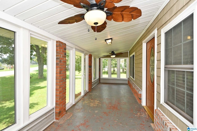 unfurnished sunroom featuring ceiling fan and a wealth of natural light