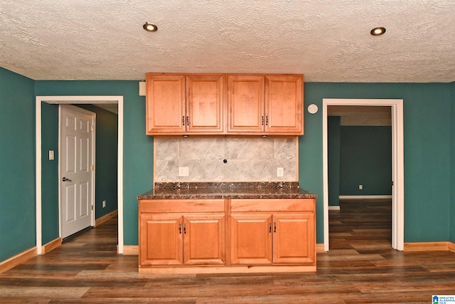 kitchen featuring decorative backsplash, wood-type flooring, and a textured ceiling