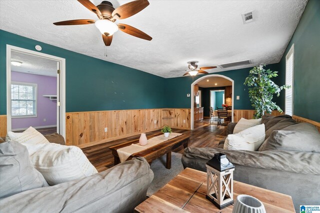 spare room with a textured ceiling, ceiling fan, and dark hardwood / wood-style flooring