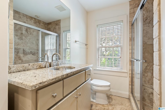 bathroom with tile patterned flooring, a shower with shower door, vanity, and toilet