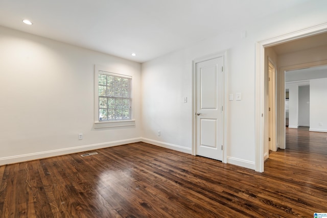 spare room featuring dark wood-type flooring