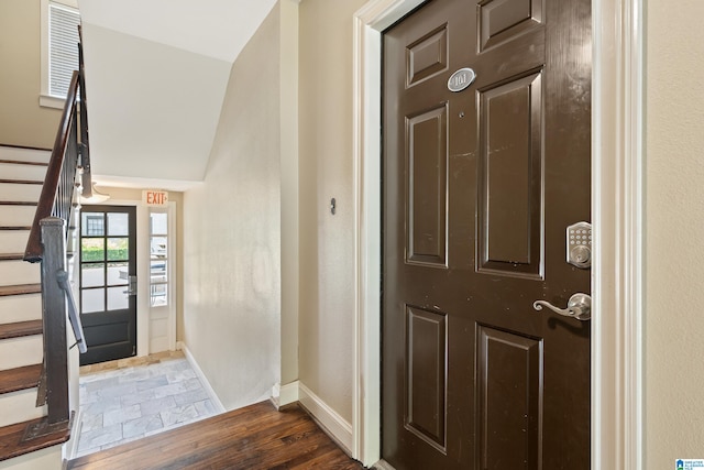 foyer with dark hardwood / wood-style floors and vaulted ceiling