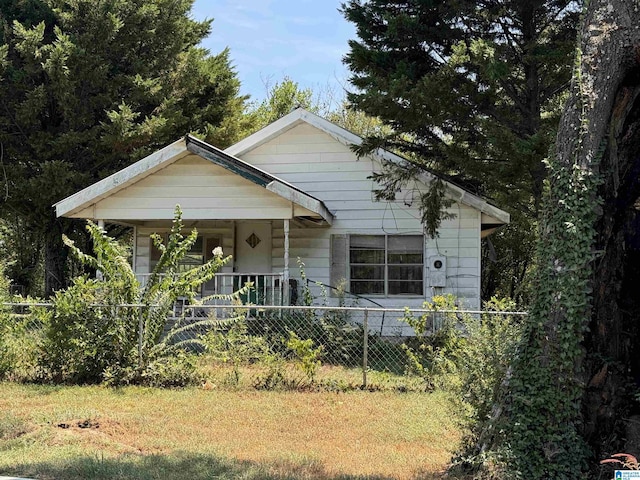 bungalow with covered porch and a fenced front yard