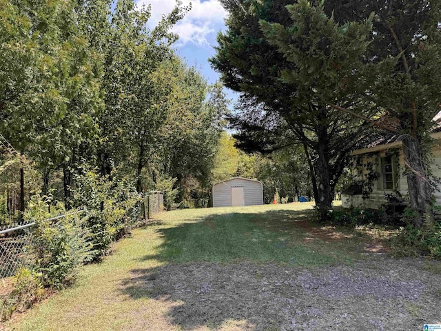 view of yard with a shed, an outdoor structure, and fence