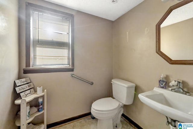 bathroom with sink, tile patterned flooring, and toilet