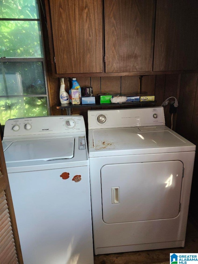 clothes washing area featuring independent washer and dryer and cabinets