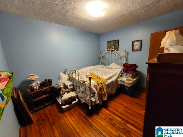 bedroom featuring hardwood / wood-style flooring and a textured ceiling