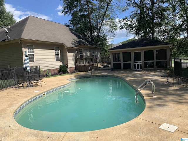 view of pool featuring a patio, fence, a sunroom, and a fenced in pool