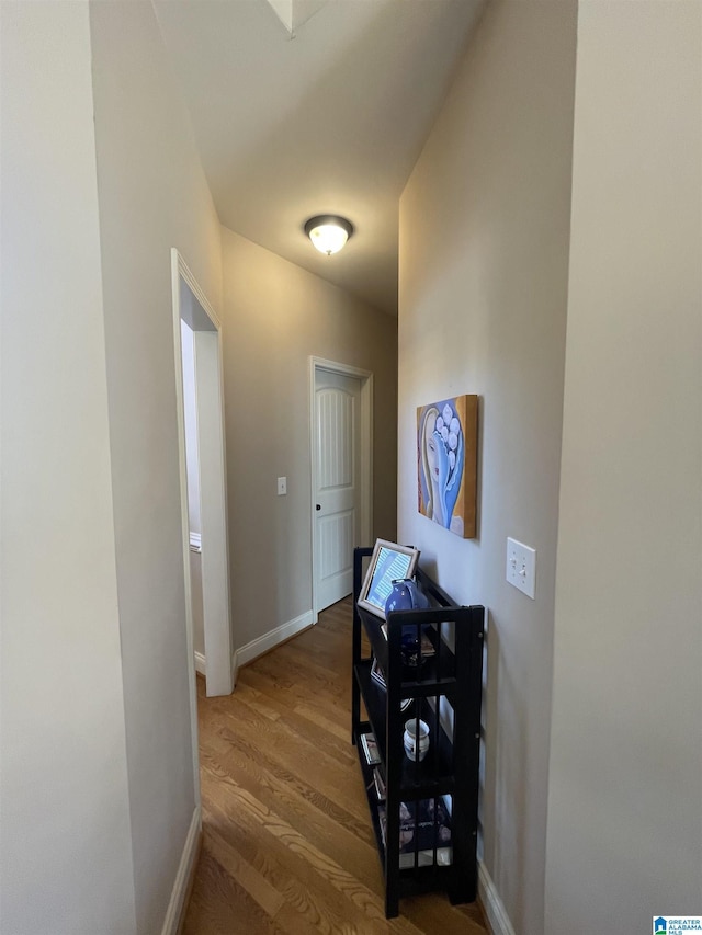 hall featuring baseboards and wood finished floors