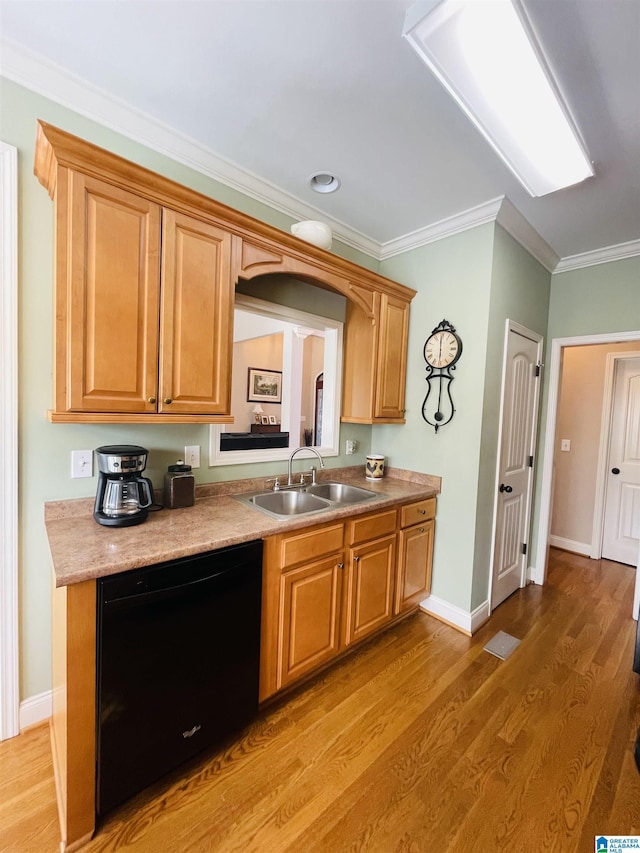 kitchen featuring black dishwasher, crown molding, light countertops, a sink, and light wood-type flooring