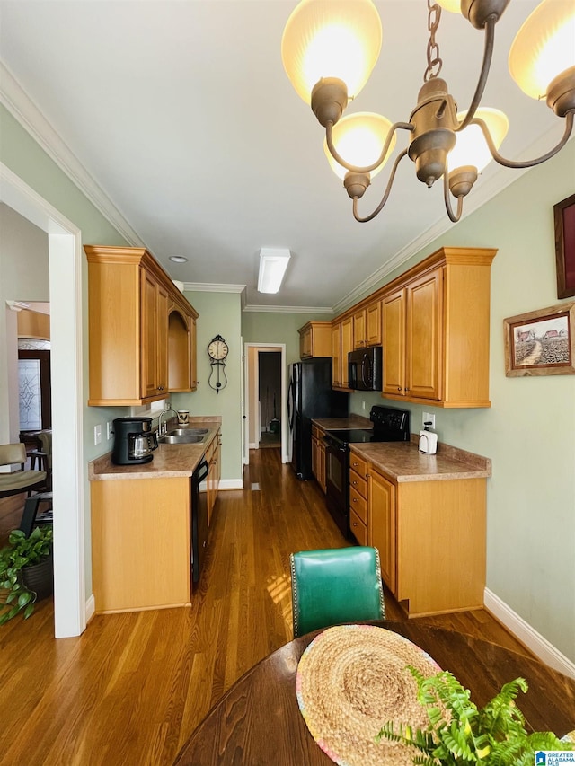 kitchen featuring dark wood-style flooring, baseboards, crown molding, and black appliances