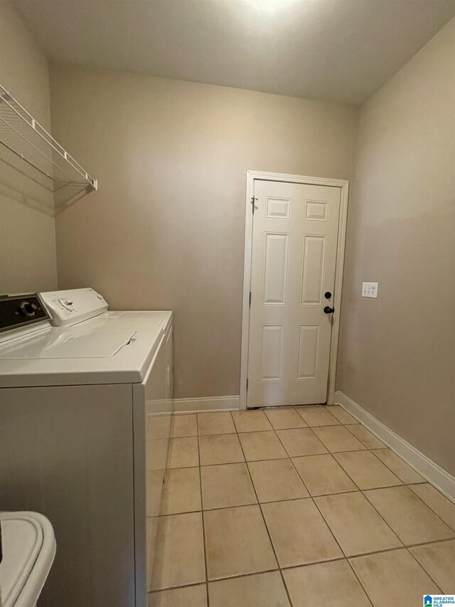 laundry area with washing machine and dryer and light tile patterned flooring