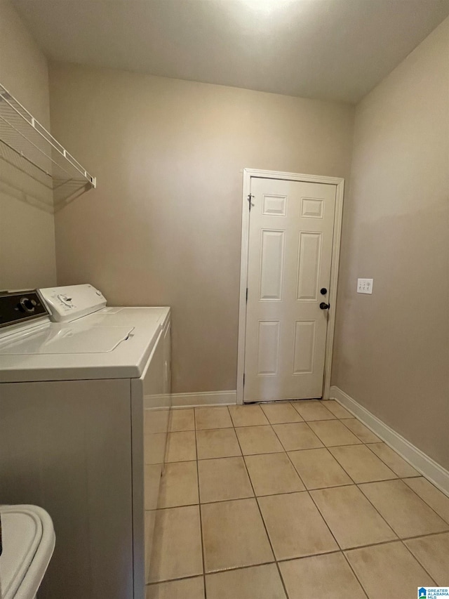 laundry area with laundry area, baseboards, washing machine and clothes dryer, and light tile patterned floors