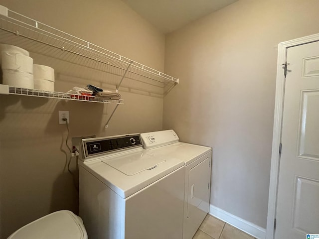 laundry room with washing machine and dryer, laundry area, baseboards, and light tile patterned floors