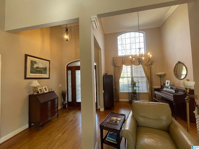 living room with a notable chandelier, crown molding, and wood-type flooring