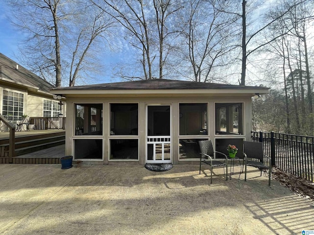 rear view of property featuring fence and a sunroom