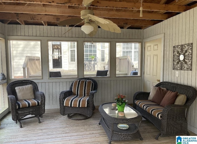 sunroom / solarium featuring a ceiling fan and beamed ceiling